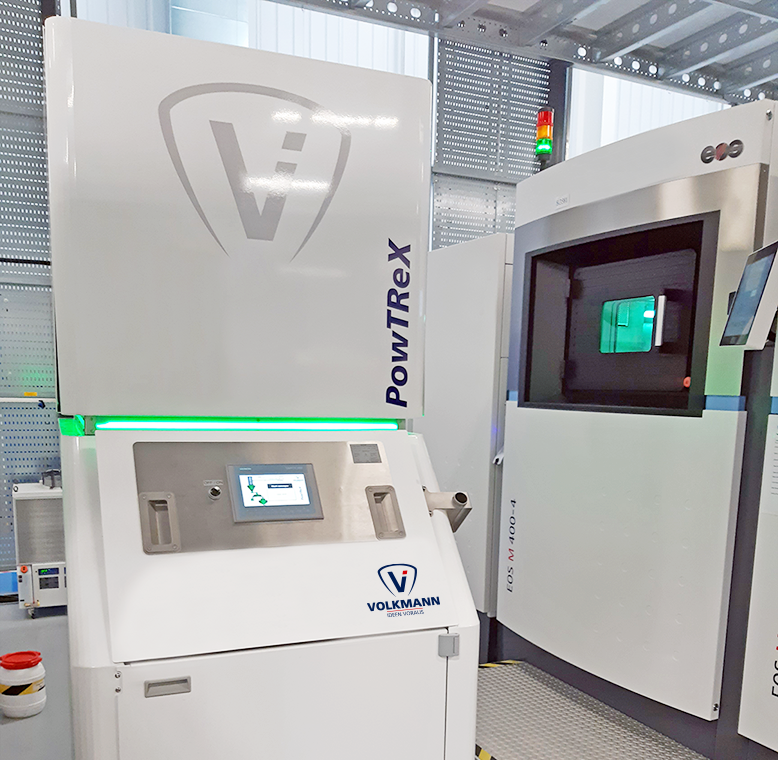 Photo demonstrating additive manufacturing system with PowTReX and 3D printer